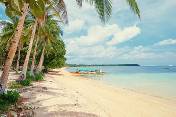 Beautiful landscape with tropical white sand beach with fishing boats. Siargao Island, Philippines.