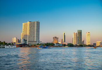Fototapeta na wymiar Bangkok, Thailand - January 5, 2020: Chao Phraya River and city skyscrapers from Asiatique Waterfront at sunset,.