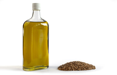 Hemp oil in a bottle with a bunch of cannabis seeds. Isolated on white background.