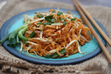 Thai food Pad Thai Thai stir-fried noodles (national dish) served in blue plate.