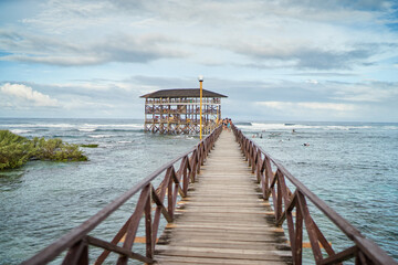 Obraz premium Beautiful landscape. Day on seashore. Wooden bridge on Cloud 9 beach, Siargao Island Philippines.