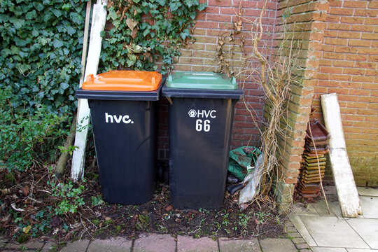 Two containers, bins at a Dutch house for plastic waste and for green waste that is collected by the waste processing company HVC (Huisvuilcentrale). Bergen, Netherlands, February