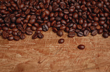 Roasted coffee beans in selective focus on wooden table
