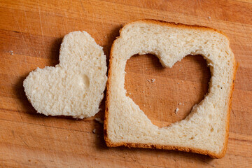 A heart made of toast bread on a wooden board. Congratulations on Valentine's Day.