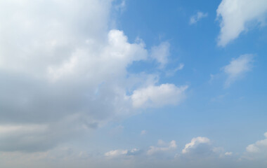 Clear blue sky with white fluffy clouds at noon. Day time. Abstract nature landscape background.