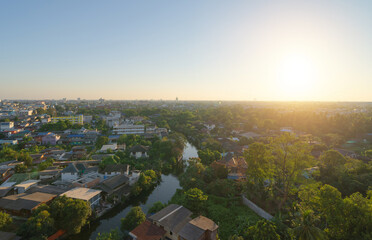 Fototapeta premium Aerial view of residential houses with nature trees, Wutthakat district, Bangkok City, Thailand in urban city in Asia. Residential houses, buildings at sunset.