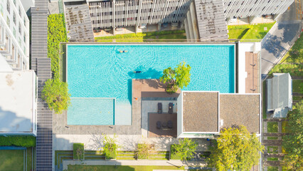Aerial view of swimming pool on rooftop of hotel apartment building in Bangkok downtown skyline, urban city view. Relaxing in summer season in travel holiday vacation concept. Recreation lifestyle.