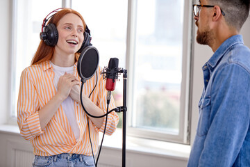 Man and woman recording music, man playing piano, enjoy performing music, preparing for concert or...