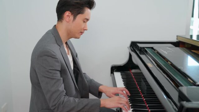 Pianist teach a boy to play piano in the classroom at school. Favorite classical music. Happy and fun during learning. Musician in formal elegant suit. Education, practice and relaxation concept.