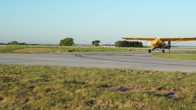 Small high wing airplane taxis off runway at rural airport