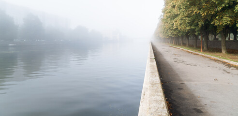 Heavy fog on the city embankment