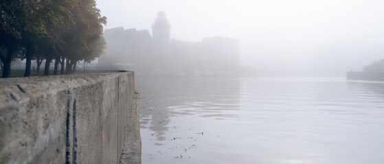 Heavy fog on the city embankment