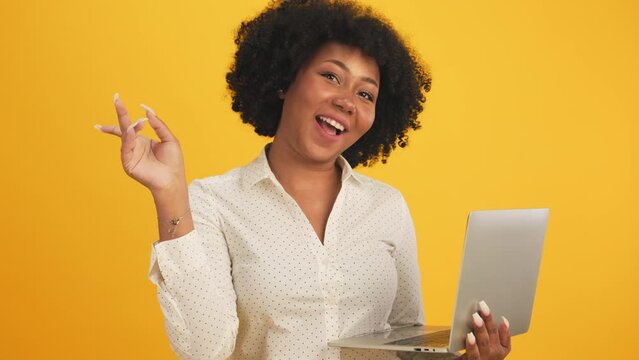 Happy smiling African American woman with afro hairstyle happy positive smile chat email laptop isolated over  color background.