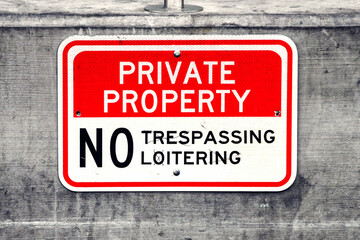 Close up view of a "Private property - No Trespassing or Loitering" sign. No people.