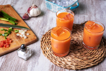 Fototapeta na wymiar Gazpacho, cold soup typical of Andalusia based on tomato, garlic, pepper and onion. Presented in small glasses to drink.