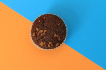 Chocolate muffin isolated on color background. Delicious chocolate muffin with nuts.