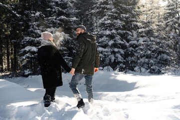 Fototapeta na wymiar love and vacation concept - happy couple hugging and laughing outdoors in winter.couple in nature