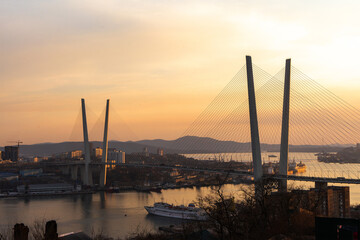 Cable-stayed bridge Golden across the Golden Horn strait at sunset or sunrise, Vladivostok, Primorsky Krai, Russia