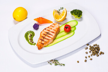 Special fish plate made by a restaurant chef with broccoli lemon avocado and tomatoes