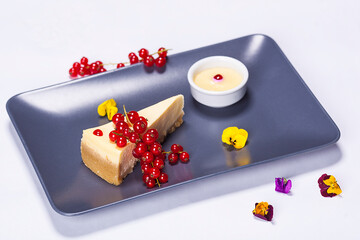 Cheese cake plate made by a restaurant chef. Composition made with fruits and different flowers