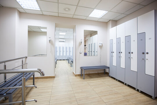 wide frame with a white locker room with wooden cabinets and benches