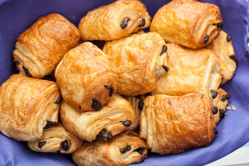 Fresh croissants and bakery arranged in a basket with a red material for protection