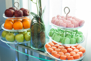 plate with sweets, delicious sweet cupcakes lie on tree glass plate and one with apple and oranges