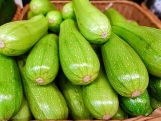 Large  fresh young vegetable marrows in the supermarket closeup. Fresh organic zucchini.