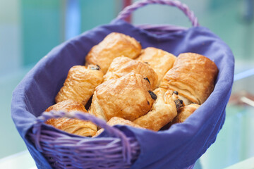 Fresh croissants and bakery arranged in a basket with a red material for protection