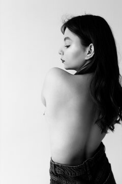 Black and white photo of a girl without a bra in the studio