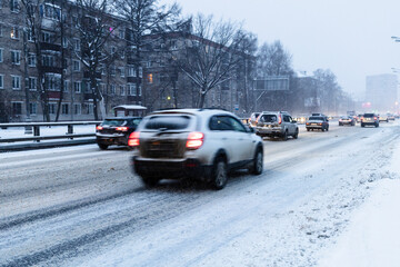 traffic on snowy city road in blue winter dusk