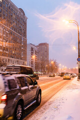 snow-covered city road in winter evening