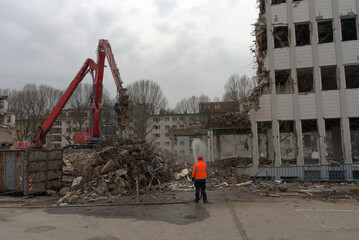 Demolition of an office building in Berlin, workers sprayed with a water hose. 