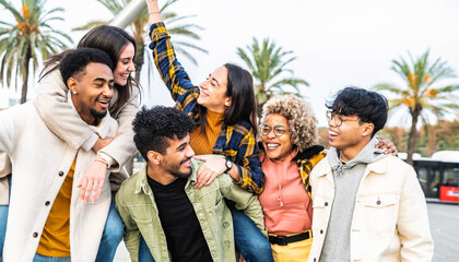 Fototapeta premium Multiracial group of friends bonding outside - Happy young people walking down the street laughing and having fun - Adult students hangout together in the city center - Friendship lifestyle concept