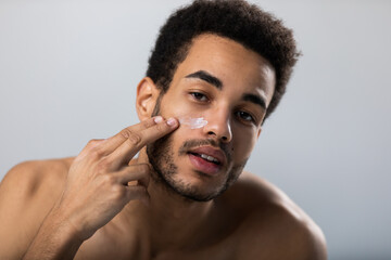 Attractive man doing facial beauty treatments.