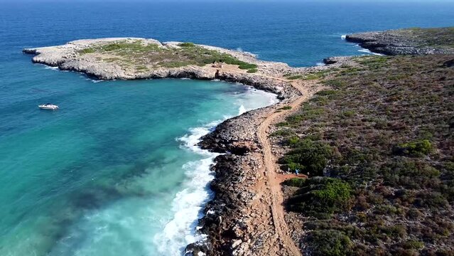 Calas y costa de Palma de Mallorca desde dron a&eacute;reo. Agua de colores azules claros turquesas, olas rompiendo contra las rocas. Sendero al lado de la costa donde poder caminar.
