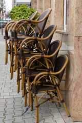 Stacked cane chairs outside a restaurant in town