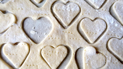 Hearts in soft rolled dough with a wooden rolling pin for valentine's day