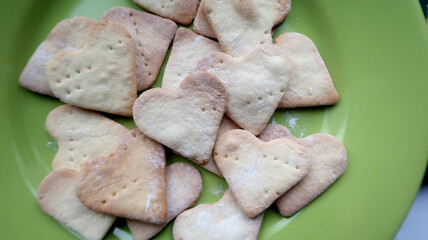A full green plate of sweet homemade heart-shaped cookies for the holiday