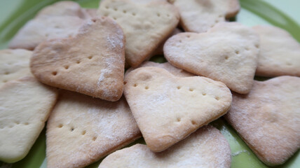 A full green plate of sweet homemade heart-shaped cookies for the holiday