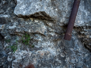 imagen detalle piedra gris con un tubo de hierro oxidado