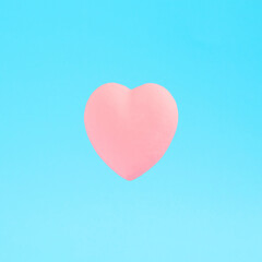 Fototapeta na wymiar Pastel pink heart on a blue background. Minimal creative concept for Valentine's Day, love, tenderness, Mother's Day.