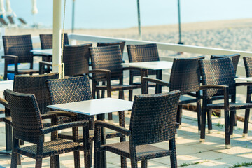 Range of wooden table and black chair for relaxation at restaurant near sea