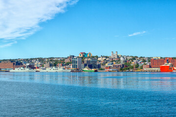 Fototapeta na wymiar St. John's, Newfoundland, Canada - February 2022: Colorful downtown St. John's with historic wooden residential, commercial, business, and Federal Government buildings. There are colorful ships docked