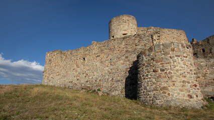 Fototapeta na wymiar Fortification médiévale en ruine sur une colline des montagnes cévenoles sous le ciel bleu d'été en France.