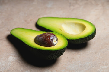 Fresh vegetables - Zutano avocado on a table with a black background. Contrasting image of a tasty vegetable