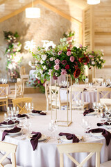 Festive wedding table setting with flowers, napkins, cutlery, glasses, bright summer table decor. Wedding decor