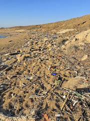 A lot of plastic, garbage and waste lies on the seashore and on the beach. Environmental disaster in nature. Environmental pollution in North Cyprus
