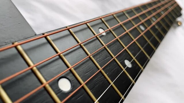 Zoom in shot of black frets fretboard acoustic guitar string. 