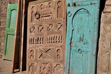 Beautiful old wooden doors on display for sale at Bab el Khemis flea market. Marrakech, Morocco.